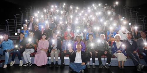 ◇3일 춘천 축제극장 몸짓에서 열린 포토콘서트 ‘덕분에’에서 참석자들이 사진작가 김남덕의 앞날에 행운을 빌면서 휴대전화의 조명을 환히 밝히고 있다. 박승선기자