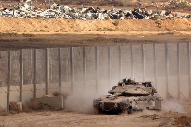 이스라엘군 탱크가 지난달 25일 이스라엘과 팔레스타인 가자지구를 나누는 장벽 옆을 지나가고 있다. AFP 연합뉴스