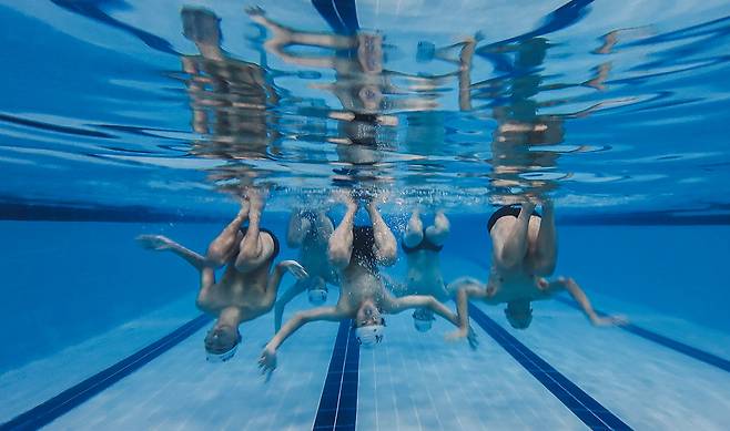 SMAT 선수들이 물속에서 거꾸로 선 채로 연기를 펼치고 있다. 올림픽과 세계선수권 대회의 수심은 3m 이상이며, 경기장은 물속의 동작을 볼 수 있도록 깨끗해야 한다.