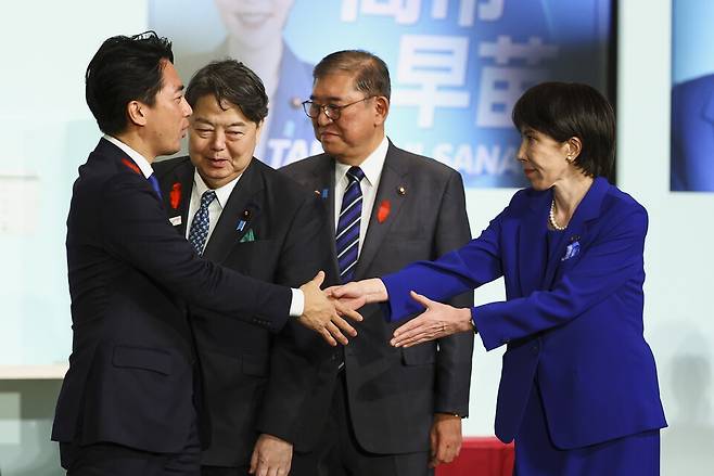 10월 4일 일본 도쿄에서 열린 자민당 총재 선거 결선 투표에서 다카이치 사나에 전 경제안보담당상이 승리한 후 고이즈미 신지로 농림수산상과 악수를 하고 있다. ⓒ EPA 연합