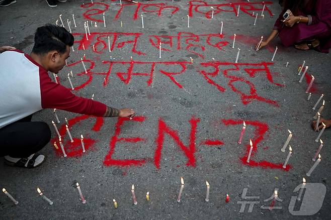 9월 17일(현지시간) 네팔 카트만두에서 시민들이 '순교자들이여 영원하라'라는 문구 옆에 촛불을 밝히고 있다. 이날 카트만두에서는 네팔 전역에서 발생한 시위 도중 숨진 시민들을 기리기 위한 '국가 애도의 날' 묵념 행사가 열렸다. 2025.09.17. ⓒ AFP=뉴스1 ⓒ News1 윤다정 기자