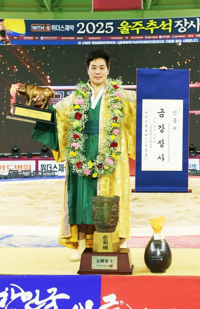 6일(월) 울산광역시 울주군 울주종합체육센터에서 열린 ‘위더스제약 2025 울주추석장사씨름대회’ 금강장사(90kg이하)에 등극한 최정만(영암군민속씨름단)이 장사인증서와 황소트로피를 들고 기념사진을 찍고 있다./대한씨름협회