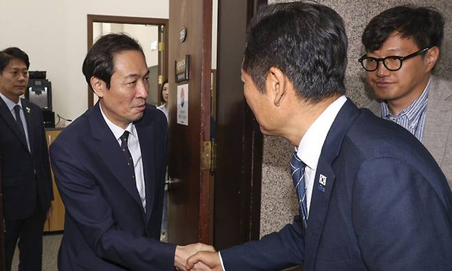 우상호 대통령실 정무수석(왼쪽)이 지난 9월 25일 정청래 더불어민주당 대표와 국회 민주당 대표실에서 금융정책·감독분리 관련 긴급 고위 당·정·대 회의를 마친 뒤 악수하고 있다. 연합뉴스
