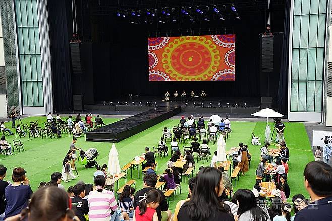 4일 낮 국립아시아문화전당을 찾은 방문객들이 다양한 아시아 음식을 먹으며 예술극장 빅도어 무대에서 공연을 관람하고 있다.