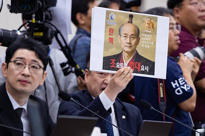 최혁진 무소속 의원이 13일 서울 여의도 국회에서 열린 법제사법위원회의 대법원 등에 대한 국정감사에서 조희대 대법원장에게 질의하며 손팻말을 들어보이고 있다. /뉴스1