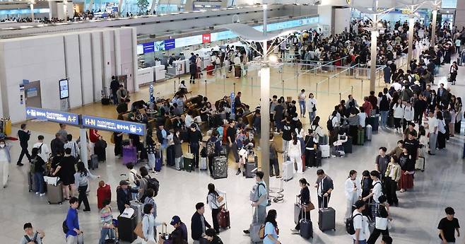 추석 연휴 첫 날인 지난 3일 인천국제공항 제1여객터미널에서 여행객들이 탑승 수속을 위해 줄을 서고 있다. 연합뉴스