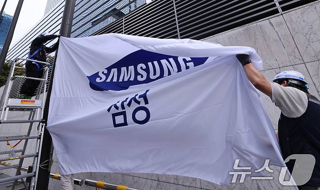 14일 서울 서초구 삼성전자 서초사옥에서 관계자들이 사기를 새 것으로 교체해 게양하고 있다. 이날 삼성전자는 올 3분기 12조 원대의 영업이익을 기록하면서 반등에 성공했다. 매출액은 역대 분기 최고치를 경신했고 '10조 클럽'에 재차 가입했다. 2025.10.14/뉴스1 ⓒ News1 박지혜 기자