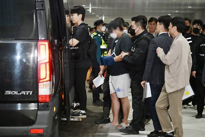 캄보디아 온라인 사기에 가담해 구금된 한국인들이 18일 오전 인천국제공항 제2터미널을 통해 송환돼 호송차에 오르고 있다. 사진=연합뉴스
