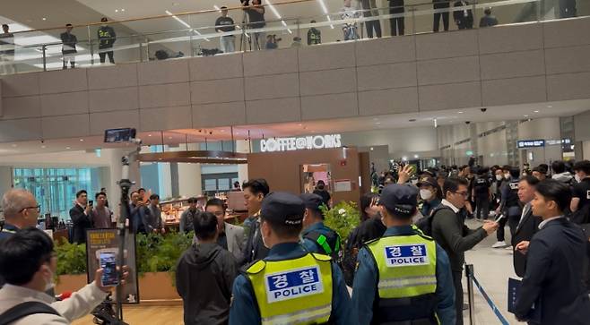 18일 오전 10시쯤 공항 입국장에서 한 남성이 송환자들의 이동 경로를 쫓아가다 경찰에 제지당하고 있다. 김수정 기자