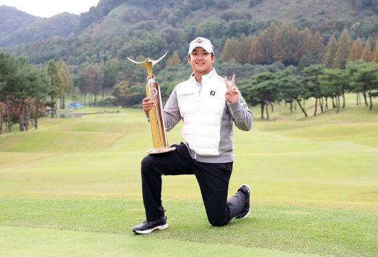 최승빈이 더 채리티 클래식 우승 직후 트로피를 무를 위에 올려놓고 환하게 웃고 있다. KPGA 제공