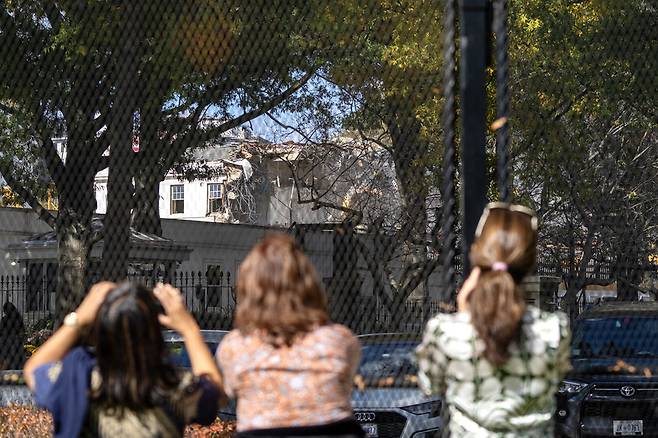 22일 미국 워싱턴디시에서 시민·관광객들이 백악관 이스트윙 철거 작업 모습을 지켜보고 있다. 이번 철거는 도널드 트럼프 대통령이 지시한 국빈들을 접대할 수 있는 대규모 연회장 건설을 위한 것이다. UPI연합뉴스