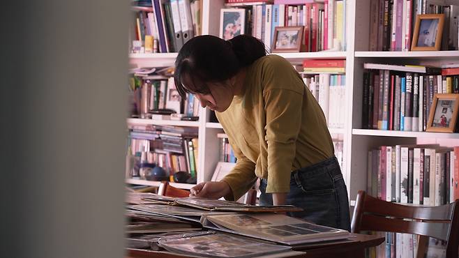 다큐멘터리 영화 <양양>의 양주연 감독이 돌아가신 고모 양지영씨의 사진을 들여다보고 있다. 영화사 진진 제공.