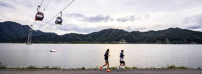 '공지천교'에서 러닝 스타트를 끊을 경우 '춘천삼악산호수케이블카 의암호정차장' 부근까지는 2.7~3km 정도다. 러닝 동호인 김병욱씨와 박종민씨가 케이블카 아래 평지 구간을 신나게 달리고 있다. / 이신영 영상미디어 기자