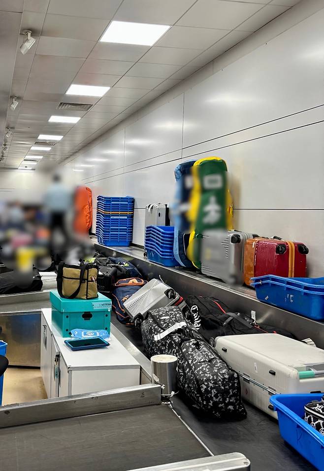 25일, 수하물 벨트가 멈추자 항공사 직원들이 직접 컨베이어 위로 올라 짐을 옮기고 있다. 교체 대상에 오른 노후 장비의 현실을 보여준다.