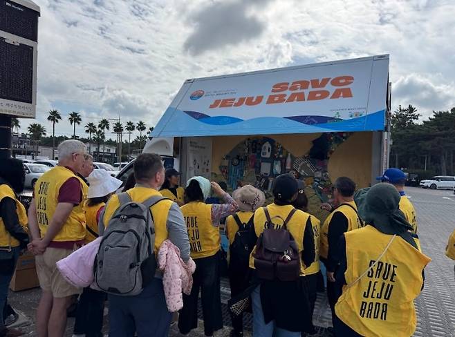 ‘세이브제주바다’ 부스 앞에서 해양쓰레기 문제를 설명 듣는 주한미군 가족들.