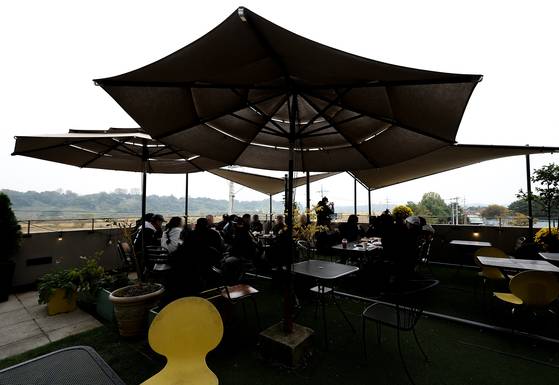 도널드 트럼프 대통령이 아시아 순방길에 오르며 북한 김정은 국무위원장과 회동 의지를 밝힌 가운데 미국 CNN은 방한 기간에 맞춰 임진각 인근 한 카페 테라스를 임대한 것으로 확인됐다. 26일 경기도 파주시에 위치한 해당 카페에서 시민들이 휴식을 취하고 있다. 연합뉴스