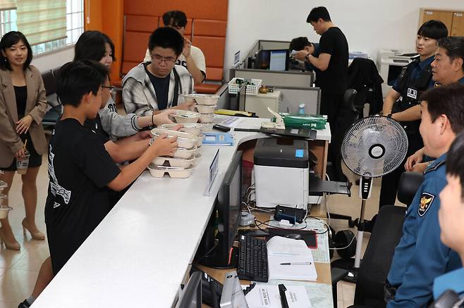 자이언 국제 상호문화 대안학교에 다니는 이주배경 학생들이 10월1일 경기도 안산시 단원구 선부동에 있는 선부2파출소 경찰관들에게 러시아식 만두를 전달하고 있다. 류우종 선임기자 wjryu@hani.co.kr