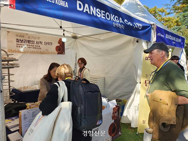 독일 특파원 일행이 29일 경주 APEC 국제미디어센터 부근에서 운영된 ‘K-푸드 스테이션’을 찾아 단석가의 찰보리빵 등을 구경하고 있다. 강정의 기자