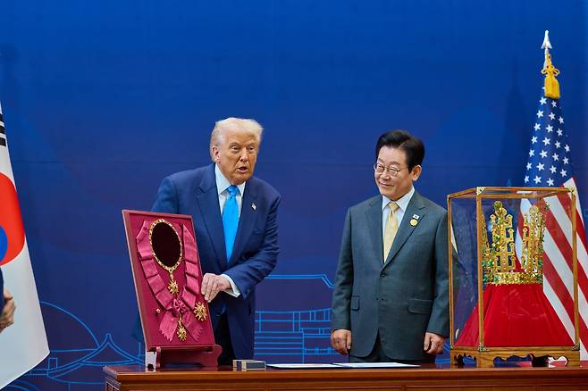 이재명 대통령이 29일 국립경주박물관에서 열린 한미 공식 환영식에서 도널드 트럼프 미국 대통령에게 무궁화 대훈장을 수여하고 천마총 금관 모형을 선물하고 있다./뉴스1