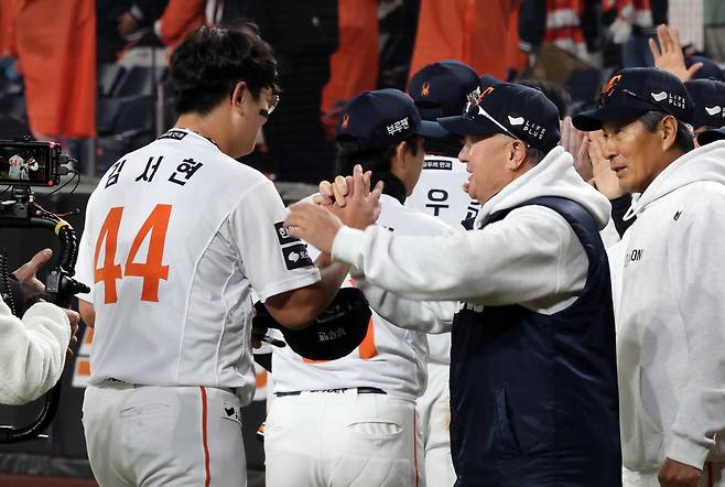 한화 김서현(왼쪽)이 29일 대전한화생명볼파크에서 열린 ‘2025 신한 SOL 뱅크 KBO PS’ LG와 한국시리즈 3차전을 마친 뒤 김경문 감독(오른쪽 두 번째)으로부터 격려를 받고 있다. 대전|뉴시스