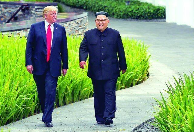 김정은 북한 국무위원장과 도널드 트럼프 미국 대통령이 지난 2018년 6월12일 싱가포르 센토사섬에서 1차 정상회담 도중 정원을 함께 걷고 있다. 한겨레 자료사진