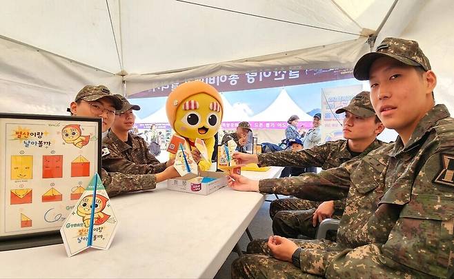 ▲ 양주 드론봇 페스티벌에서 군인들이 '별산이' 그림이 그려진 종이비행기를 만든 뒤 캐릭터 별산이와 함께 기념사진을 찍고 있다.