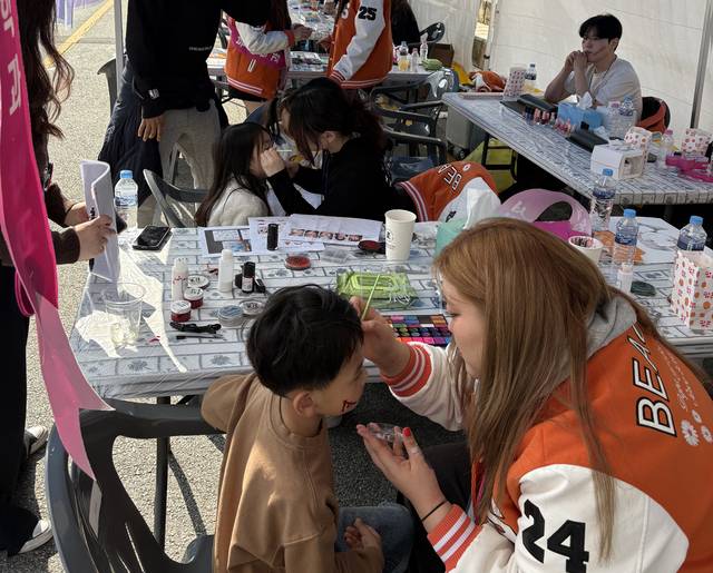 ▲ 서원대 뷰티학과 학생이 어린이 얼굴에 그림을 그려주고 있다./서원대 제공