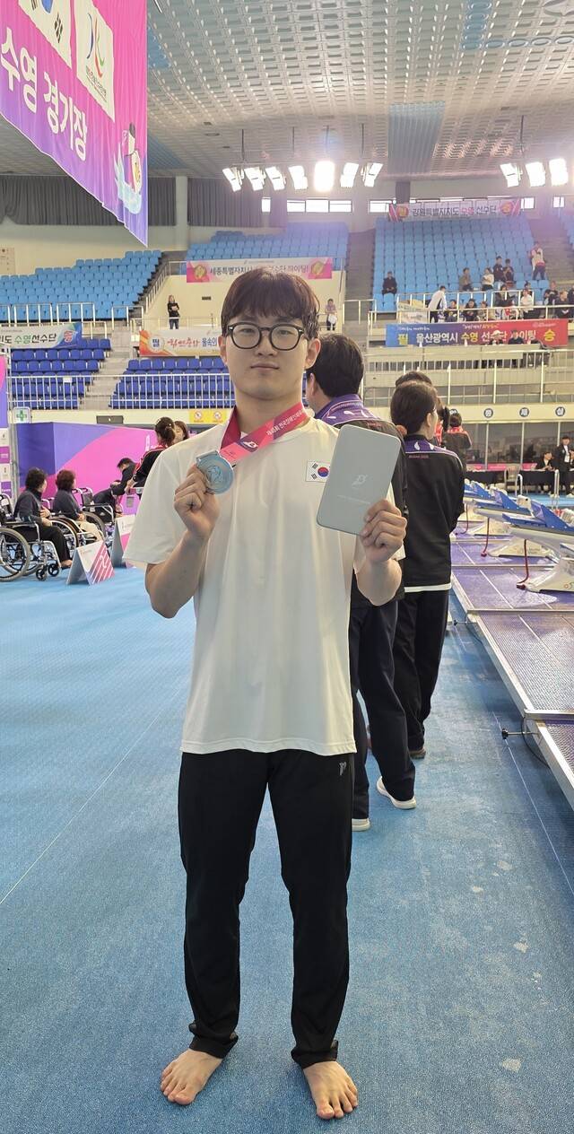제45회 전국장애인체육대회에 대구시 선수단으로 출전한 우상욱 선수가 남자 DB 평영 50m에서 획득한 은메달을 들어보이고 있다 . 대구시장애인체육회 제공