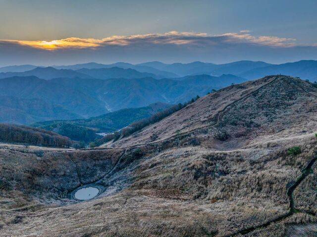 억새 명소인 강원도 정선군 민둥산 너머로 아침 해가 떠오르고 있다. 왼쪽 움푹한 곳은 카르스트 지형인 돌리네, 오른쪽 높은 곳이 민둥산 정상이다.