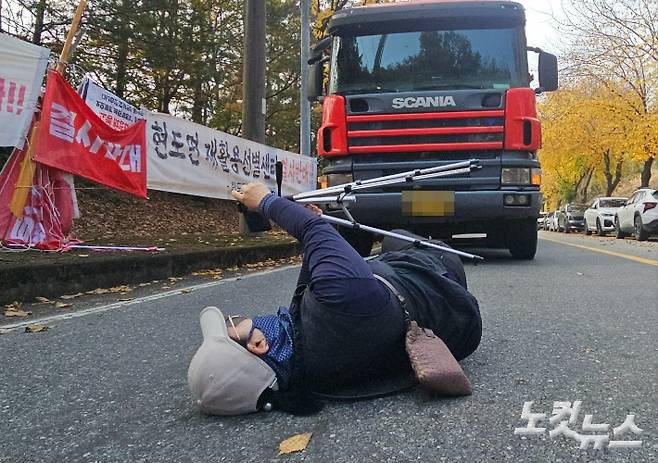 7일 충북 청주시 현도면 재활용선별센터 건립 현장에서 한 주민이 도로 위에 누워 공사 장비 진입을 막고 있다. 임성민 기자