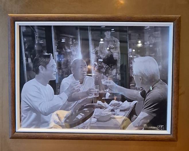 깐부치킨 삼성점 매장 벽면에 붙어 있는 사진. 젠슨 황 엔비디아 최고경영자(CEO)와 이재용 삼성전자 회장, 정의선 현대자동차그룹 회장(오른쪽부터 시계 방향으로)이 맥주잔을 든 모습이 담겨 있다. 임경진 기자