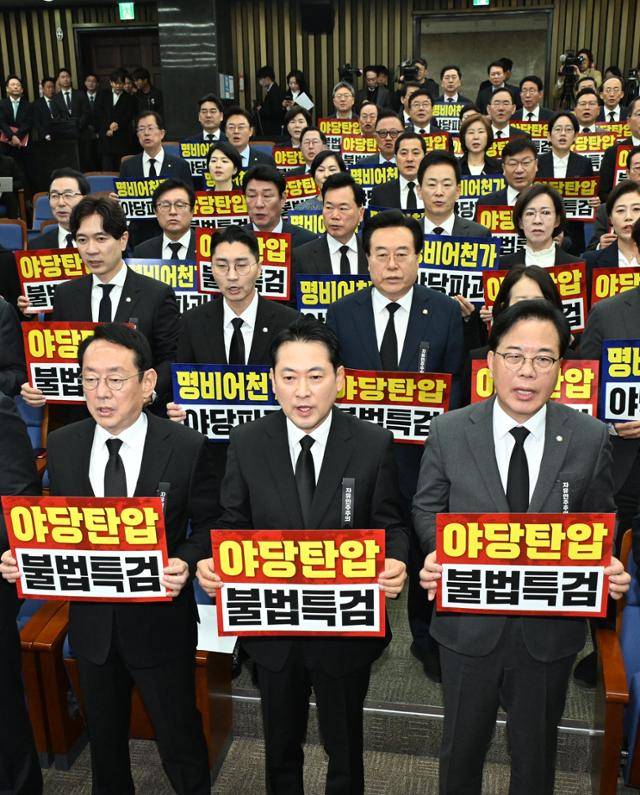 장동혁(앞줄 가운데) 국민의힘 대표와 송언석 원내대표를 비롯한 의원들이 4일 서울 여의도 국회에서 열린 의원총회에서 야당탄압과 불법특검을 규탄하는 손피켓을 들고 구호를 외치고 있다. 고영권 기자