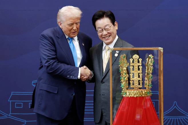 이재명 대통령이 경주박물관에서 도널드 트럼프 미국 대통령에게 '천마총 금관 모형'을 선물한 뒤 악수하고 있다. 연합뉴스