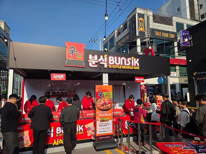 구미라면축제의 신라면 부스에 사람들이 시식 등을 하기 위해 줄을 서있는 모습./사진=차현아 기자.