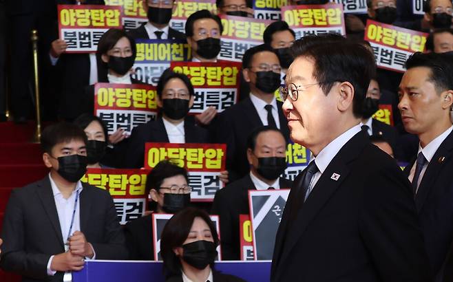 이재명 대통령이 4일 내년도 정부 예산안에 대한 시정연설을 하기 위해 서울 여의도 국회에 도착해 침묵시위를 하는 국민의힘 의원들 앞을 지나고 있다. 국민의힘 의원들은 추경호 전 원내대표에 대한 내란특검팀의 영장청구를 규탄하는 피켓을 들고서 침묵시위를 했다. ⓒ 연합뉴스