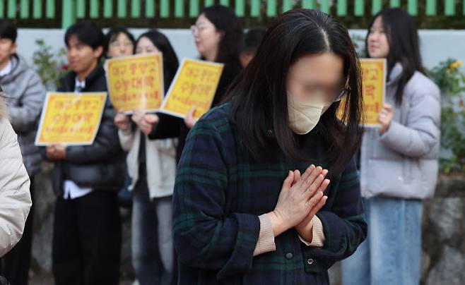 2026학년도 대학수학능력시험(수능)일인 13일 대구 수성구 대구여자고등학교 수능 시험장 앞에서 학부모가 기도하고 있다. (사진=연합뉴스).