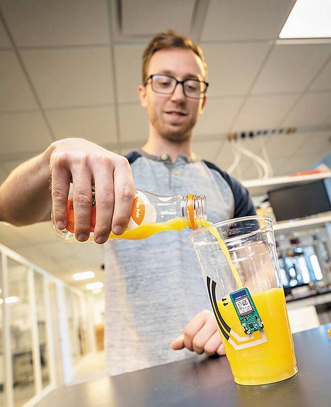 UC 샌디에이고 연구팀 연구원이 스마트컵에 오렌지 주스를 따르고 있다. 이 컵을 쥐고 있으면 비타민C 혈중 수치가 자동으로 측정된다. /UC샌디에이고