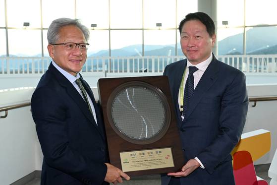 젠슨 황 엔비디아 최고경영자(CEO)가 지난달 31일 경북 경주시 경주예술의전당에서 열린 아시아태평양경제협력체(APEC) CEO 서밋에 참석해 최태원 SK그룹 회장에게 HBM4 반도체 웨이퍼를 선물로 받고 있다. 김성룡 기자
