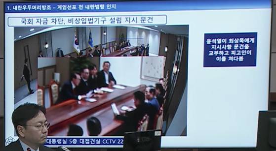 최상목 전 기획재정부 장관이 계엄 당일 윤석열 전 대통령에게서 문건을 받아 읽고 있다. 법원cctv 캡처