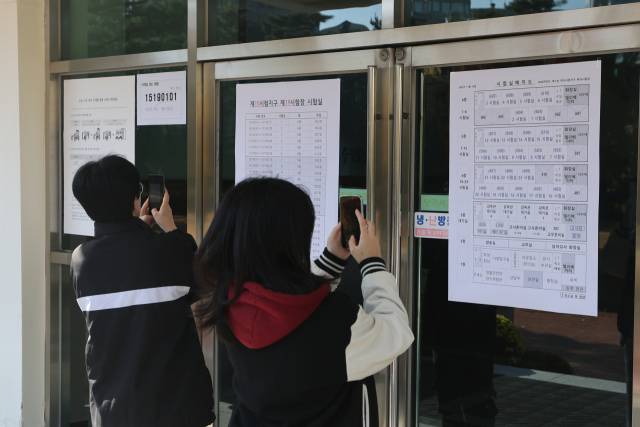 2026학년도 대학수학능력시험을 하루 앞둔 12일 서울 중구 이화여자고등학교에서 수험생과 학부모가 고사장을 확인하고 있다. 연합뉴스