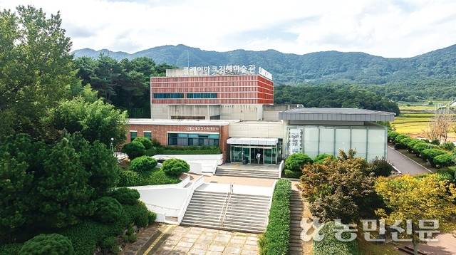 사각형으로 된 큐빅하우스. 외벽 윗부분이 1500여개의 붉은색 도기질 루버로 싸여 있다.