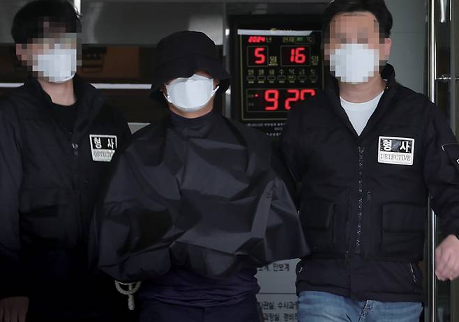 부산법원 앞에서 생방송하던 유튜버를 살해한 혐의(특가법상 보복살인)를 받는 50대 유튜버가 2024년 5월16일 부산 연제경찰서에서 검찰 송치를 위해 이동하고 있다. ⓒ연합뉴스