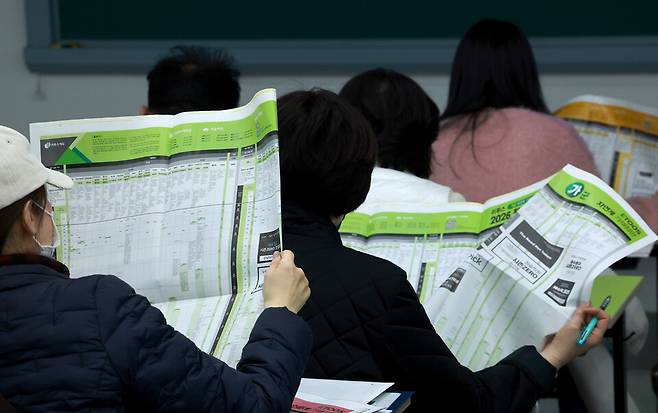 이투스에듀 주최로 지난 15일 서울 강남하이퍼학원 본원에서 열린 '2026 수능 가채점 설명회'에 참석한 수험생과 학부모들이 대학 배치 참고표를 살피고 있다. ⓒ연합뉴스
