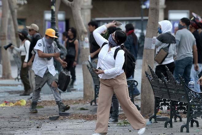 15일(현지시간) 멕시코 전역에서 Z세대가 주도하는 반정부 시위가 열린 가운데 할리스코주 과달라하라에서 한 시위대가 정부 청사를 향해 돌을 던지고 있다./AFPBBNews=뉴스1