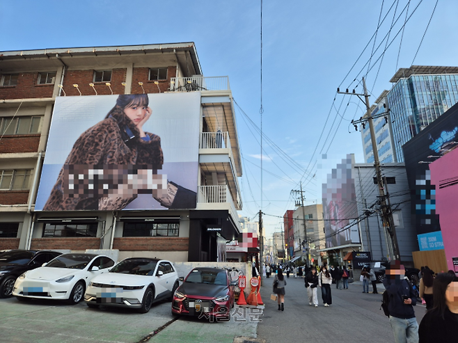 16일 서울 성동구 성수동 연무장길에 있는 건물에 한 브랜드 광고 모델 현수막이 걸려있다. 이 거리에는 건물 2층 위로 내걸린 초대형 현수막이 곳곳에 있는데 광고 단가는 한 달 1200만~7000만원에 달하는 것으로 알려졌다.
