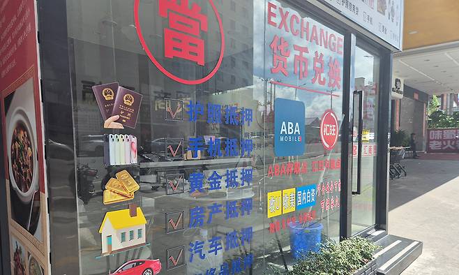 지난달 15일 캄보디아 시아누크빌 한 범죄단지 앞 환전소 모습. 창문에는 ‘테더(가상화폐) 매입’, ‘중국 내 합법 자금 취급’, ‘위챗페이·알리페이 실시간 입금 가능’ 등 광고 문구가 적혀 있다. 시아누크빌=윤준호 기자