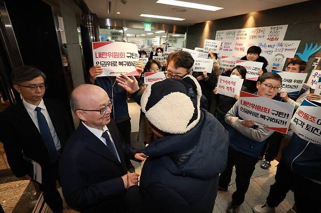 ‘윤석열 방어권 안건’이 전원위에 상정된 지난 1월13일, 안창호 위원장이 14층 엘리베이터에서 내리자 한 시민이 안창호 위원장에게 다가가 안건 철회를 요청하고 있다. 그 뒤로는 인권위 직원들이 ‘내란옹호 안건’을 규탄하는 손팻말을 들고 있다. 정용일 선임기자 yongil@hani.co.kr