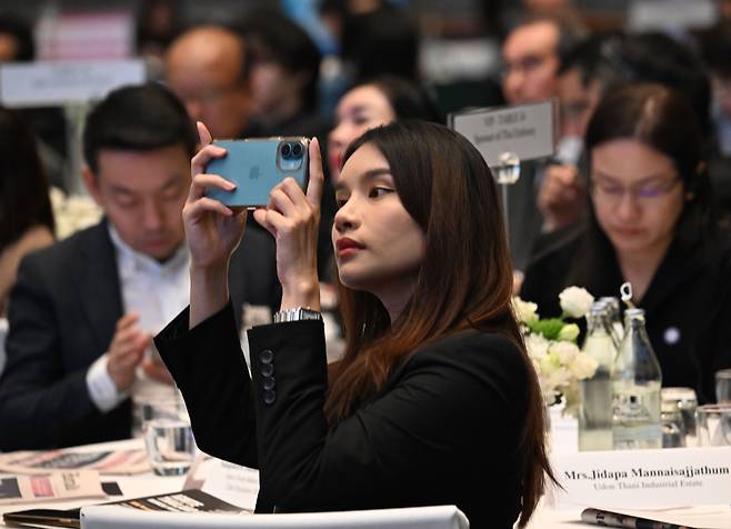 한 여성 참석자가 연사의 강연 내용을 휴대폰으로 촬영하는 모습 방콕=박해묵 기자