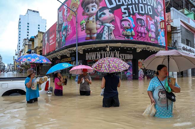 23일(현지시간) 태국 남부 송클라주 핫야이 지역에서 주민들이 침수된 거리에서 물을 헤치며 이동하고 있다. 로이터연합뉴스