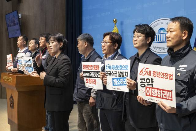 지난 5일 국회에서 진보당 윤종오 의원과 한국노총, 민주노총이 주최한 65세 법정 정년 연장 입법 연내 촉구 기자회견 참석자들이 손팻말을 들고 있다. 연합뉴스